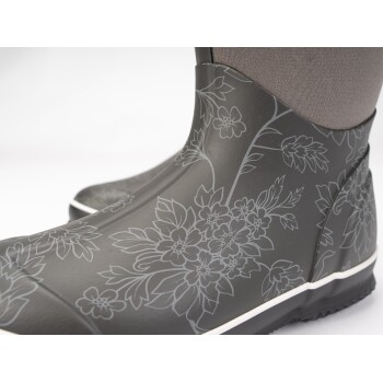 Schwarze Gummistiefel mit floralem Muster und grauem Stoffoberteil, mit einer weißen Sohle und komplizierten Blumendesigns.