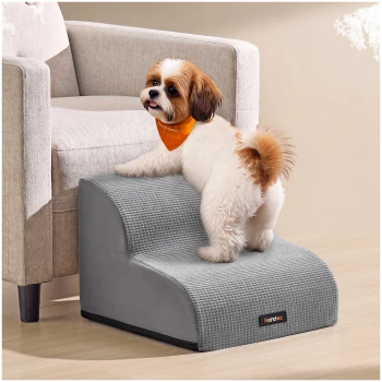 Flauschiger weiß-brauner Hund mit orangefarbener Bandana auf grauen Haustiertreppen neben einem Sessel; Etikett: 'feandrea'.