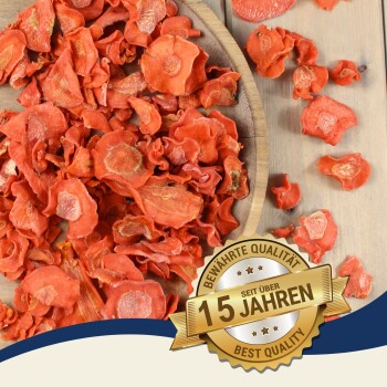 Getrocknete Karottenscheiben in einer Holzschale mit einem goldenen Siegel mit der Aufschrift „15 Jahre beste Qualität“ auf Deutsch.