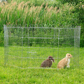 Metall-Draht-Tiergehege auf Gras mit zwei Kaninchen, eines braun und eines hellbeige, draußen.
