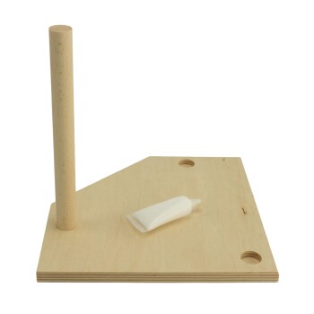 Holzspielzeug-Bauplatte für Haustiere mit einem vertikalen Pfosten und einer Tube Kleber auf einer hellen Holzoberfläche.