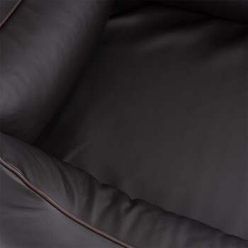 Nahaufnahme eines dunkelbraunen Haustierbettes mit plüschigen, gepolsterten Kanten, mit einer glatten, lederähnlichen Textur.