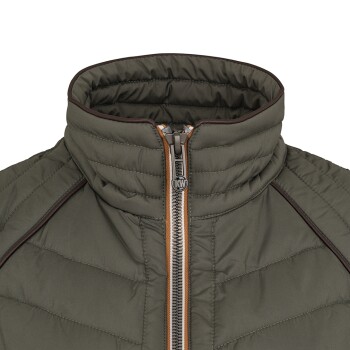 Eine Nahaufnahme einer grünen Haustierjacke mit hohem Kragen und einem Reißverschluss, mit brauner Paspelierung entlang der Nähte.