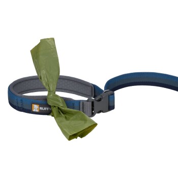 Eine blaue und graue Hundeleine mit einer grünen Mülltüte, die daran gebunden ist, mit einem "RUFFWEAR"-Logo am Griff.