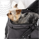 Ein kleiner Yorkshire Terrier sitzt in einem grauen Haustierwagen mit einem Netzoberteil, das sein flauschiges Fell und seinen wachsamen Ausdruck zeigt.
