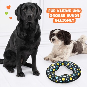 Ein schwarzer Hund und ein kleiner weiß-brauner Hund sitzen neben einem bunten herzförmigen Hundebett. Text: "FÜR KLEINE UND GROSSE HUNDE GEEIGNET."