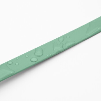 Eine Nahaufnahme eines mintgrünen Haustierhalsbands mit Wassertropfen auf der Oberfläche, vor einem weißen Hintergrund.