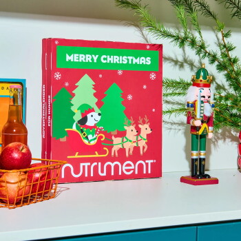 Ein haustierfreundlicher Adventskalender mit einer grünen Seite, die einen Hund zeigt, und einer roten Seite mit einem Lebkuchenmann, der sagt "FROHE WEIHNACHTEN."