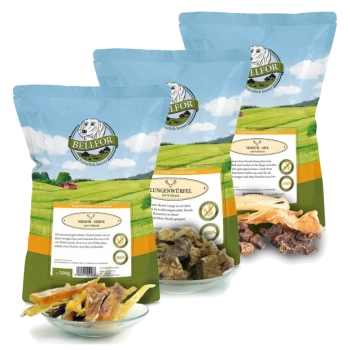 Drei Säcke BELLFOR-Haustierleckereien, beschriftet mit 'Hirsch-Mix', 'Hirsch-Würfel' und 'Hirsch-Snacks', mit einer Schüssel assortierter Trockenfleischstücke davor.