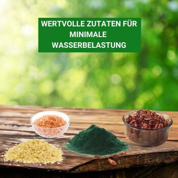 Tierfutterzutaten auf Holz: gelbes Pulver, grünes Pulver, rote Flocken, orange Stücke, mit dem Text "WERTVOLLE ZUTATEN FÜR MINIMALE WASSERBELASTUNG."