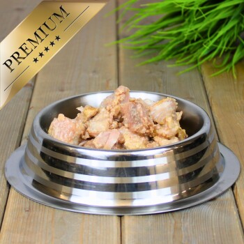 Eine Futterschüssel aus Edelstahl, gefüllt mit Fleischstücken, gekrönt mit einem goldenen "PREMIUM"-Label, auf einer Holzoberfläche.