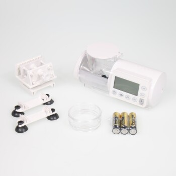 Ein weißer automatischer Futterspender für Haustiere mit einem digitalen Display, einem klaren Futterbehälter, Saugnapfbasis, einer kleinen Schüssel und Batterien.