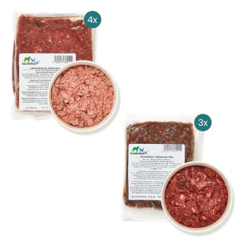 Rohe Haustierfutterpakete mit der Aufschrift "Lammischung" und "Pferdefleisch" mit Nährwertinformationen, neben Schalen mit rohem Fleisch.