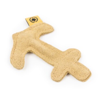 Ein beigefarbener, plüschiger Hundespielzeug in Form eines Knochens, mit einem kleinen Etikett mit einem Logo in der Ecke.