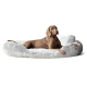 Ein entspannter brauner Hund liegt auf einem plüschigen, runden grauen Hundebett mit weicher Textur, das Komfort und Stil zeigt.