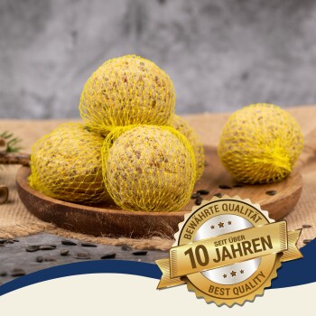 Vier gelbnetzige Vogelfutterbälle auf einem Holztablett, mit einem Abzeichen, das "Beste Qualität" und "10 Jahre" auf Deutsch angibt.