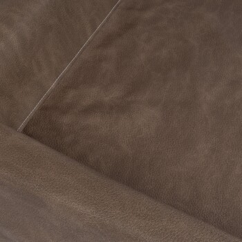 Nahaufnahme einer weichen, braunen Lederoberfläche mit subtiler Textur und einem weißen Nähdetail entlang der Naht.