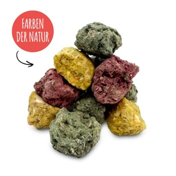 Haufen naturfarbener Mineral‑Nuggets für Haustiere (grün, gelb, rot) mit rotem Etikett 'FARBEN DER NATUR'.