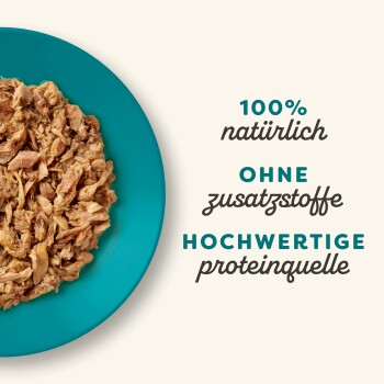 Zerrissenes Fleisch auf einem türkisfarbenen Teller mit dem Text: "100% natürlich, ohne Zusatzstoffe, hochwertige Proteinquelle."