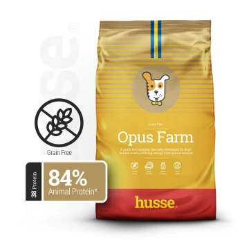 Eine Tüte Husse Opus Farm Hundefutter, mit einer getreidefreien Formel, mit einem Cartoon-Hundelogo, das "84% tierisches Protein" und "38% Protein" angibt.