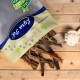 Eine Tüte Hundeleckerlis mit dem Aufdruck "Pawtastic" und einem blauen Logo, mit verschiedenen Trockenfleisch-Sticks, die auf einer Holzoberfläche neben einem Seilspielzeug verstreut sind.
