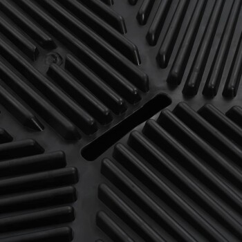 Nahaufnahme einer strukturierten schwarzen Gummimatte mit erhöhten Rillen und Rillen, entworfen für die Verwendung durch Haustiere.