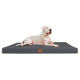 Ein großer weißer Hund liegt auf einem grauen Haustierbett mit einem Lederetikett, das Komfort und Stil zeigt.
