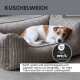 Orthopädisches Hundebett mit einem Memory-Schaum-Boden und gepolsterten Seitenkissen, mit einem flauschigen Hund, der darauf ruht.
