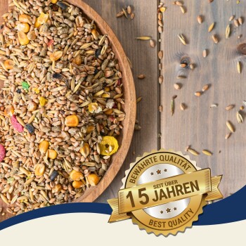 Eine Holzschüssel mit buntem Vogelfutter und einem goldenen Abzeichen mit der Aufschrift "Beste Qualität" und "10 Jahre" auf Deutsch.