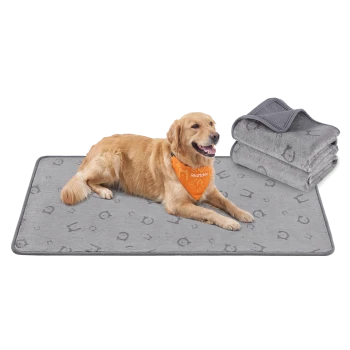 Golden Retriever liegt auf einer grau gemusterten Haustiermatte neben gefalteten, passenden Decken, trägt ein orangefarbenes Halstuch mit der Aufschrift 'Feandrea'.