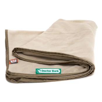 Eine gefaltete beige Haustierdecke mit einem grünen 'Doctor Bark'-Logo und einem kleinen roten Etikett in der Ecke, das ihre weiche Textur zeigt.