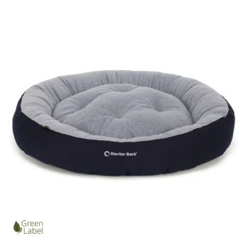 Rundes Haustierbett in Grau und Marineblau, mit einem gepolsterten Design und dem Logo "Doctor Bark." Grünes Label-Emblem in der Ecke.