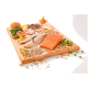 Ein Holzschneidebrett zeigt frischen Lachs und weiße Fischfilets, umgeben von Gemüse wie Kartoffeln und Salat, Nüssen, Samen und Kräutern.