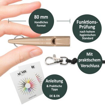Hand hält eine 80mm beige ACME-Pfeife mit Schlüsselring, Umhängebandclip und Bedienungsanleitung in Deutsch und Englisch.