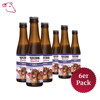 Ein 6er-Pack TJURE Superfood-Hundetränke, mit braunen Glasflaschen, die ein glückliches Hundebild und den Text 'KALB mit Beeren' zeigen.