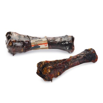 Dwa suszone kości wołowe pod łapą są wyeksponowane, jedna owinięta przezroczystym plastikiem z etykietą "beeztess Dried Beef Underpaw."