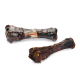 Zwei getrocknete Rinderunterpfoten-Knochen werden präsentiert, einer in klarem Plastik verpackt mit einem Etikett, das "beeztess Dried Beef Underpaw" liest.