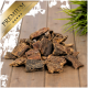 Premium Hundeleckerlis in verschiedenen Formen und Größen, auf einer Holzoberfläche mit einer grünen Pflanze im Hintergrund präsentiert.