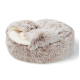 Rond, pluizig beige en crèmekleurig huisdierbed met zachte pluche binnenkant, ideaal voor kleine honden of katten.