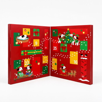 Eine Frau in einem roten Pullover öffnet einen festlichen Hundeadventskalender, während ihr brauner Hund eifrig die Leckereien darin schnüffelt.