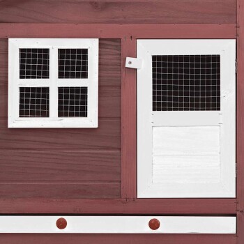 Eine Nahaufnahme eines hölzernen Haustiers mit einem weißen Fenster mit Gitter und einer weißen Tür mit einem Netzpaneel, vor einem rosa Holz-Hintergrund.