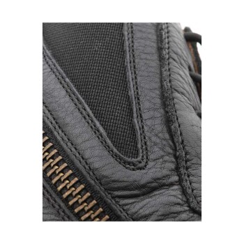 Nahaufnahme eines schwarzen Lederhandschuhs für Haustiere mit einer strukturierten Oberfläche und einem Reißverschlussdetail, das sein strapazierfähiges Design zeigt.