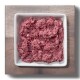 Rohe Stücke von rotem Fleisch auf einem weißen Hintergrund, die Marmorierung und Textur zeigen.