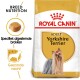 Royal Canin Adult Yorkshire Terrier hondenvoer zak met een Yorkshire Terrier met een strik, die voeding specifiek voor het ras en een gezonde vacht benadrukt.