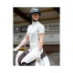 Ein Reiter in einem weißen Reitoutfit und Handschuhen sitzt auf einem Pferd, das einen schwarzen Helm trägt, in einer Indoor-Arena.