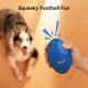 Hand hält ein blaues quietschendes Football-Hundespielzeug mit orangefarbenen Sprenkeln, darüber der Text „Squeaky Football Fun“.