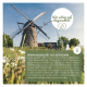 Bild einer traditionellen Windmühle, umgeben von grünem Gras und Blumen, mit Text, der hochwertiges regionales Tierfutter bewirbt.
