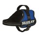 Blaue Julius-K9-Hundegeschirr mit schwarzem Innenfutter, mit einem Griff oben und reflektierenden Nähten, beschriftet mit "JULIUS-K9®".
