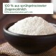 Ziegenvollmilchpulver in dunkler Schale auf gewebter Matte; Etikett: ‚100% aus sprühgetrockneter Ziegenvollmilch‘ / ‚100% spray-dried‘.