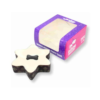 Star-shaped pet cake with creamy top, patterned brown sides and a dark bone-shaped dog treat on top.